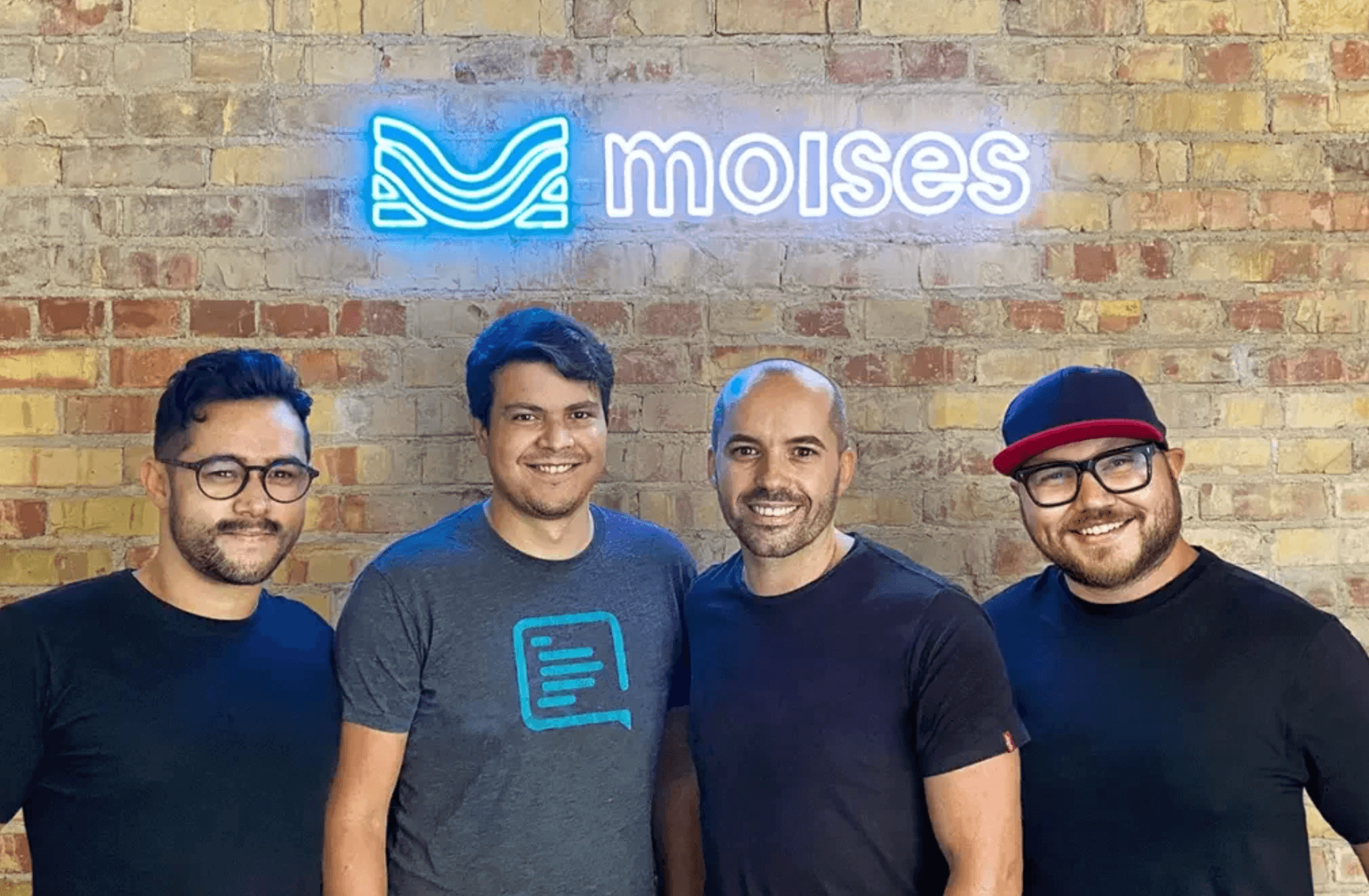 Part of Moises' leadership with a sign with the Moises logo in the background